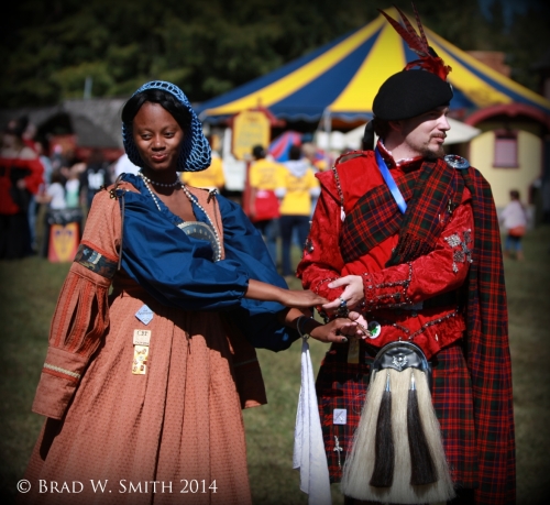 young black woman and young white man dancing outside in renaissance-period clothing. 